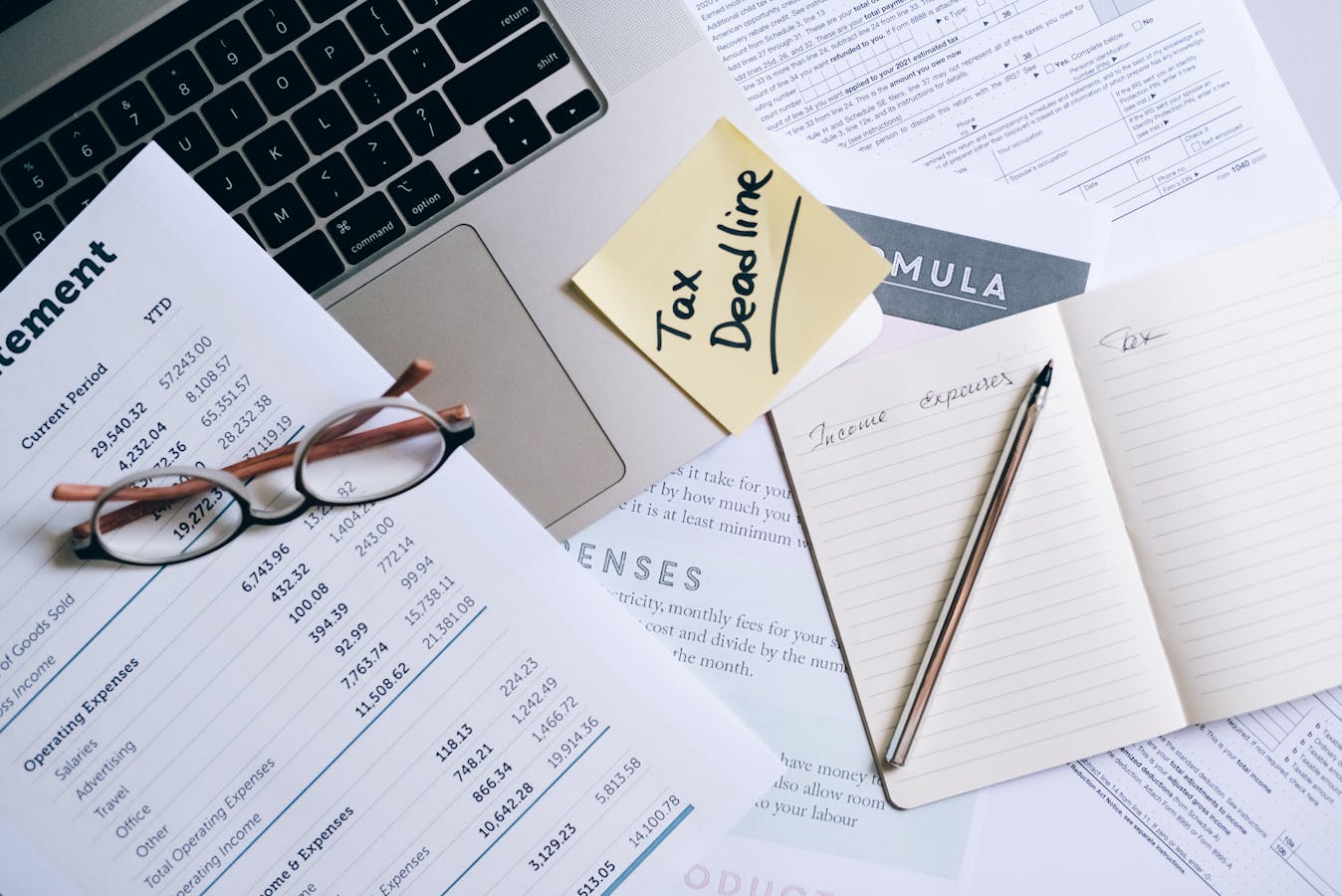 Documentos, gafas y notas sobre una mesa de trabajo editorial